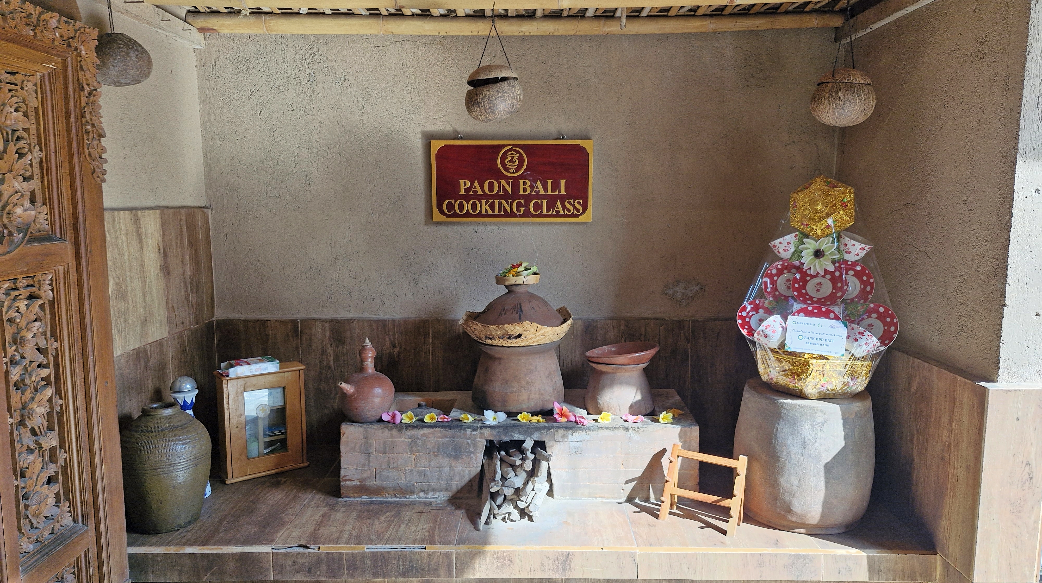 Entrance to Paon Bali Cooking Class, featuring traditional Balinese cooking tools and offerings.