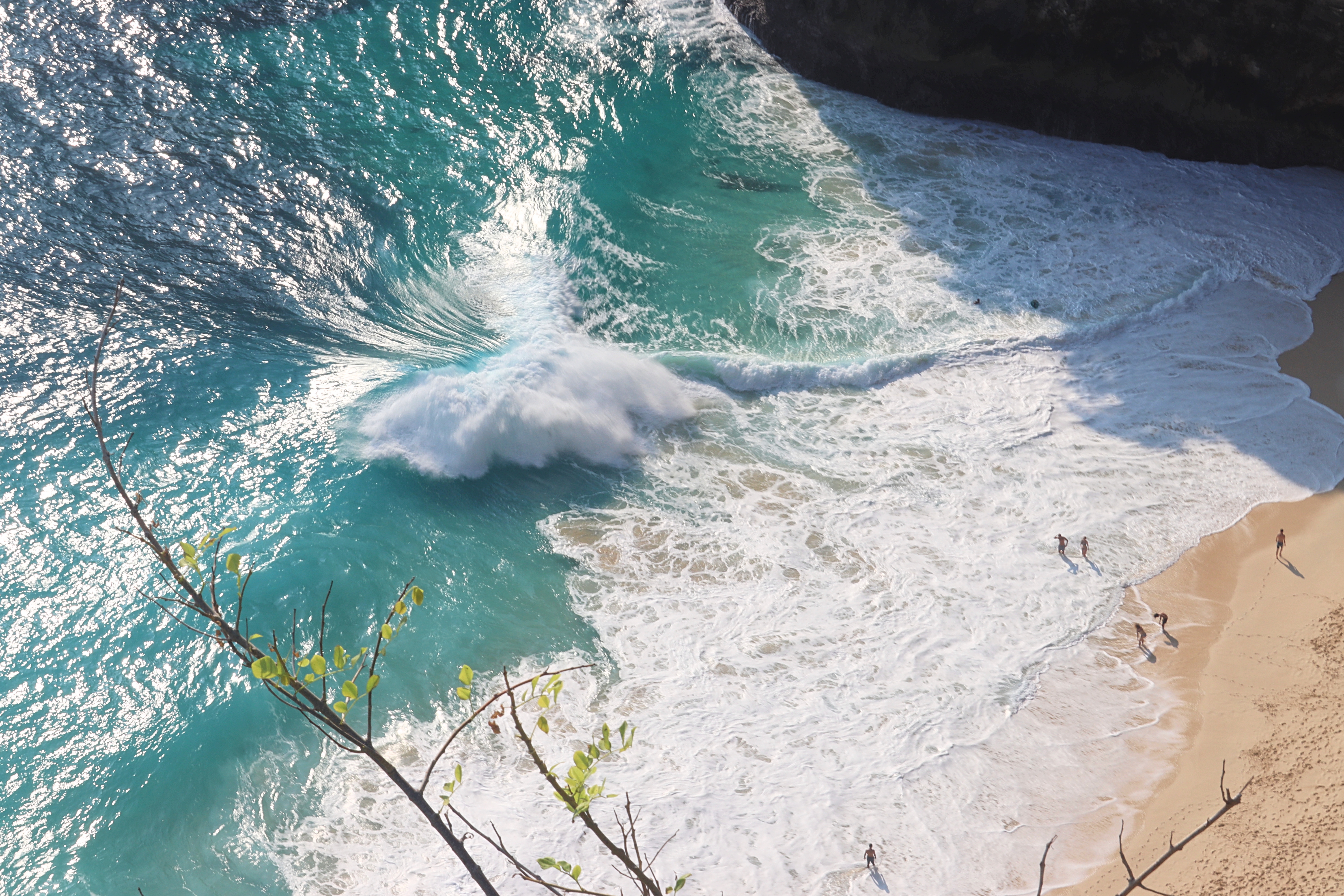 View of crashing waves on a sandy beach with turquoise water, capturing a scenic moment of nature.